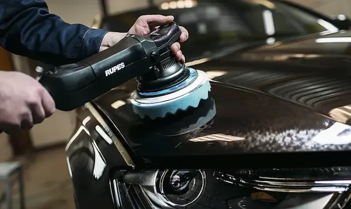 Echipa realizand polish pe caroseria unei masini